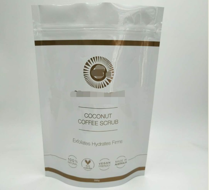 O saco de empacotamento cosmético lustroso branco, está acima o saco da folha de alumínio para o corpo embebe