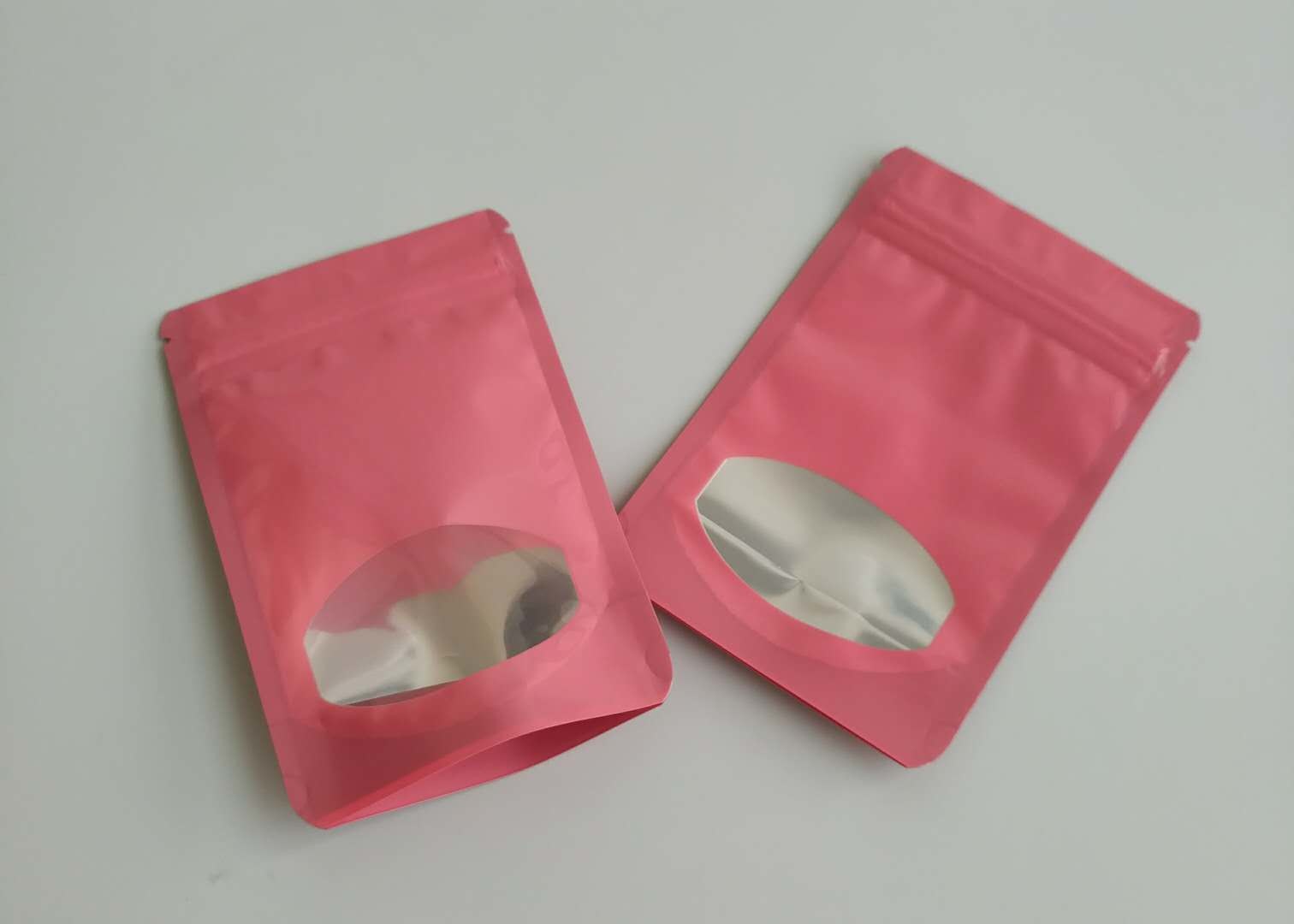 Malotes plásticos das cores diferentes que empacotam sacos dos doces do fruto do chocolate com claramente a janela